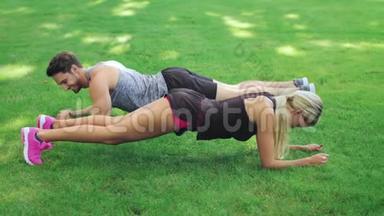 夏季公园草地<strong>健身男女</strong>训练木板运动